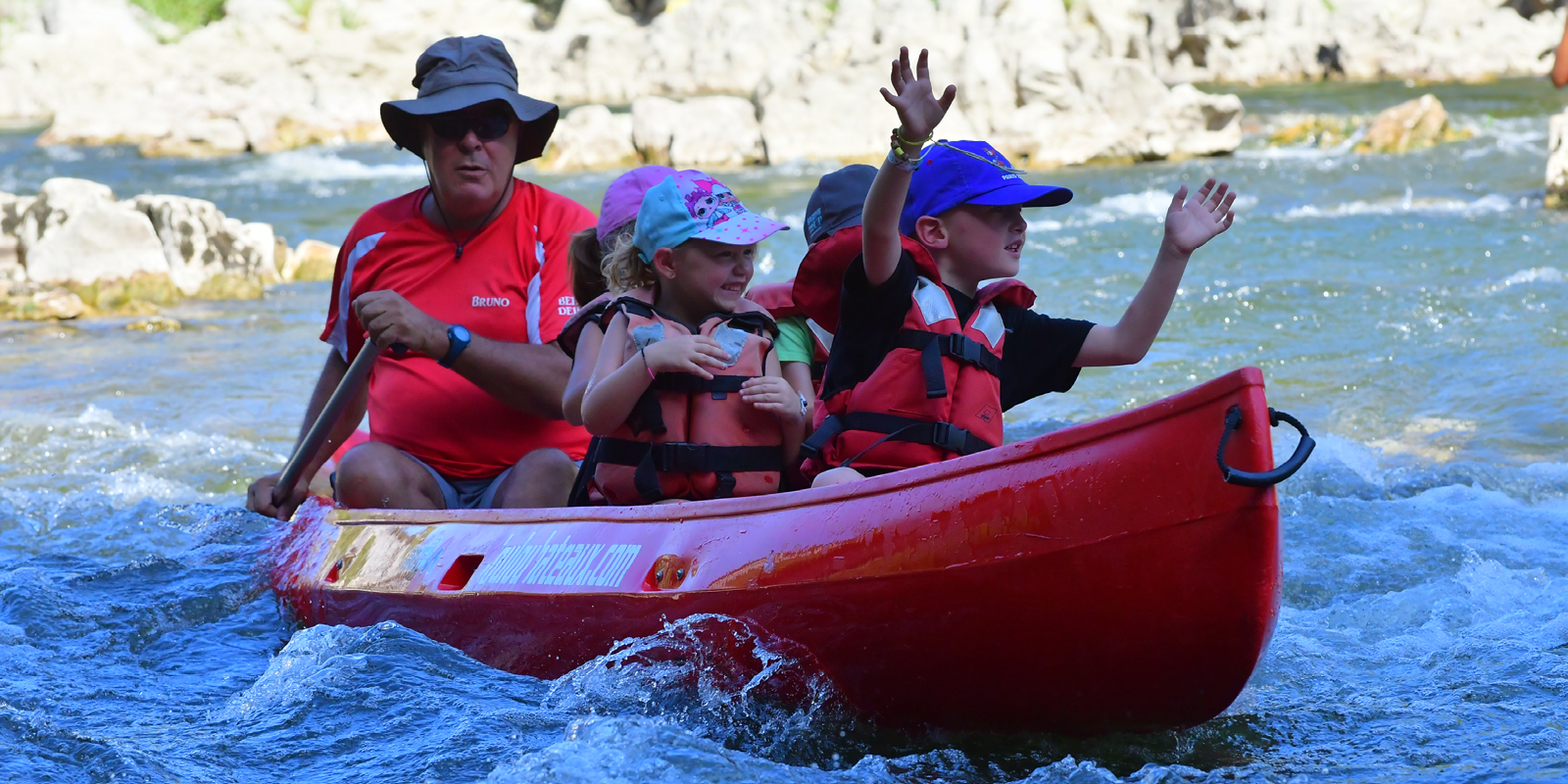 Moniteur descendant l'Ardèche en canoë avec des enfants dans le cadre d'une mini descente de l'Ardèche avec Loulou bateaux